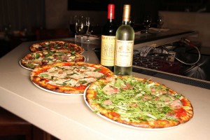 four plates of pizza and two bottle of wines